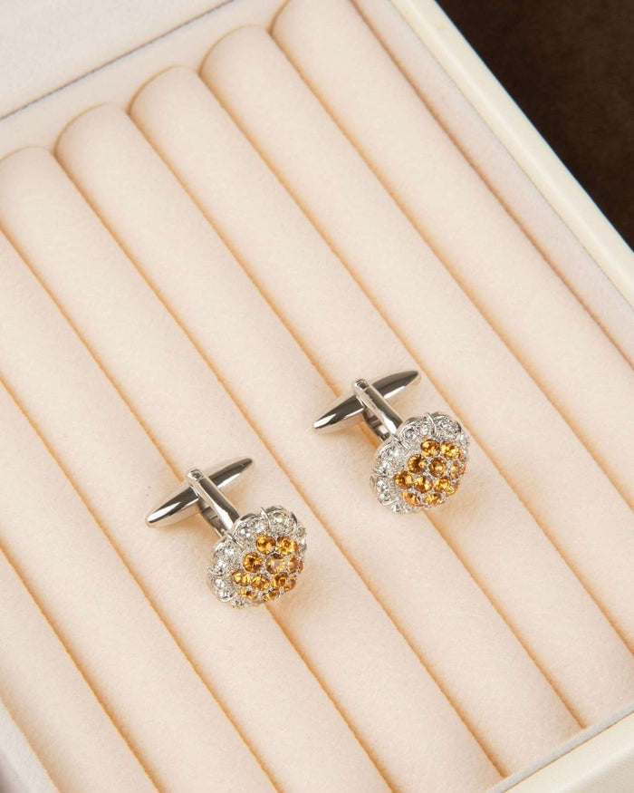Crystal cluster cufflinks on a display tray, round halo with amber center