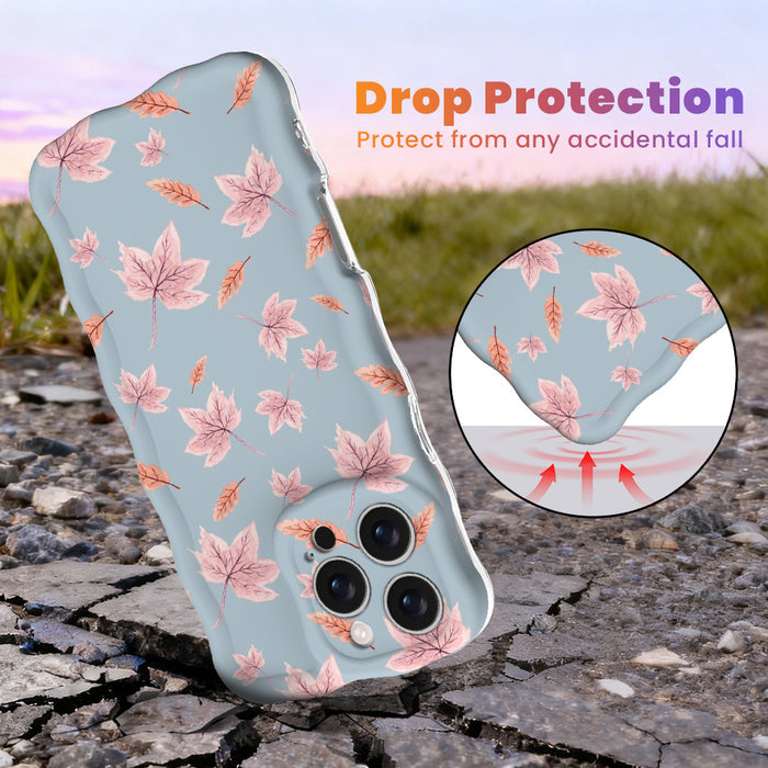 Drop protection diagram for the Autumn Breeze Wavy Luxe iPhone case, showing the shock-absorbing raised edges that protect the blue and blush maple leaf print against accidental falls.