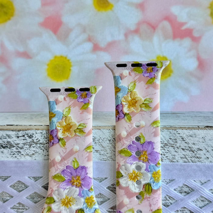 Blushing Bouquet Apple Watch band with watercolor flowers in purple, blue, yellow, and white on soft pink background