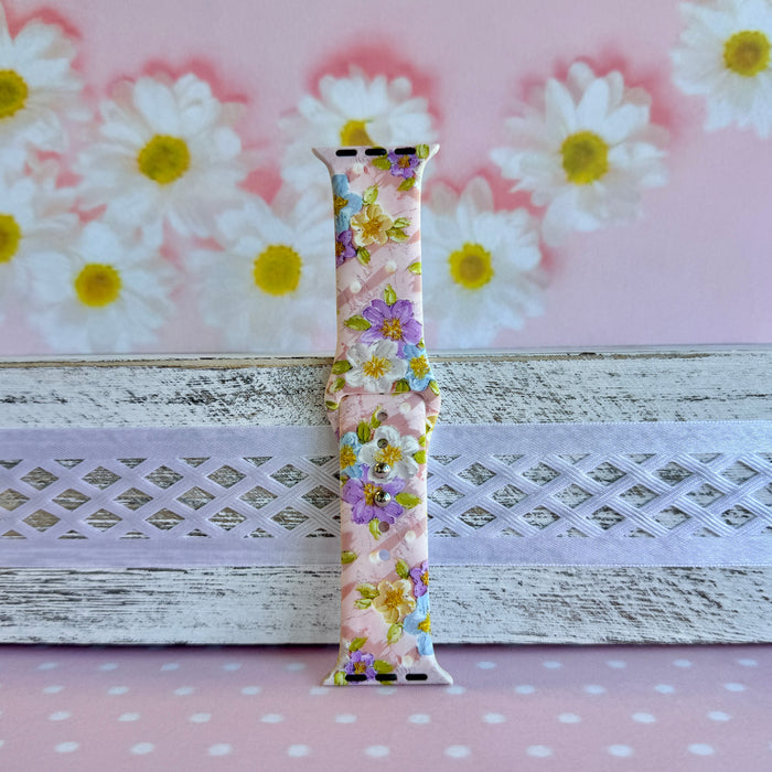 Blushing Bouquet Apple Watch band with watercolor flowers in purple, blue, yellow, and white on soft pink background