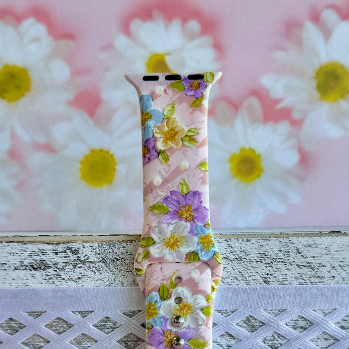 Blushing Bouquet Apple Watch band with watercolor flowers in purple, blue, yellow, and white on soft pink background