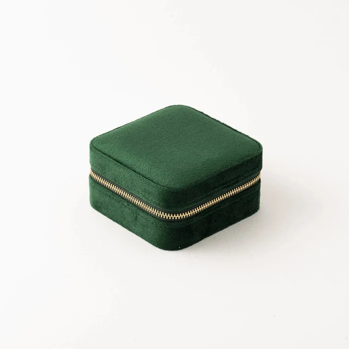 Green jewelry box with a gold zipper on a white background