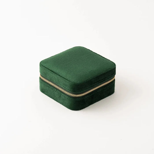 Green jewelry box with a gold zipper on a white background