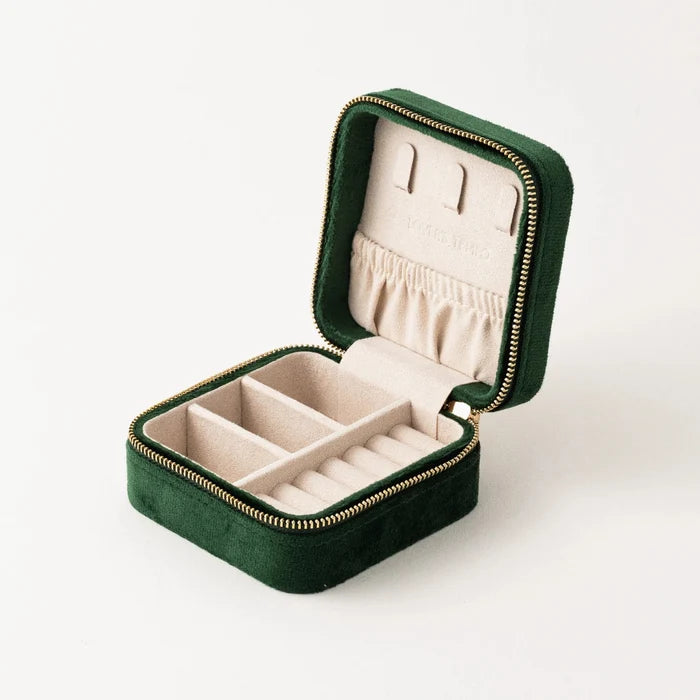 Green jewelry box with jewelry on a white background