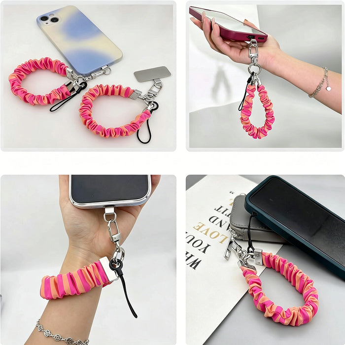 Pink and orange striped Candy Citrus Stripes scrunchie phone wrist strap clipped to the matching hot pink and citrus orange striped Wavy Luxe iPhone case, styled on a playful pink and orange heart print background.
