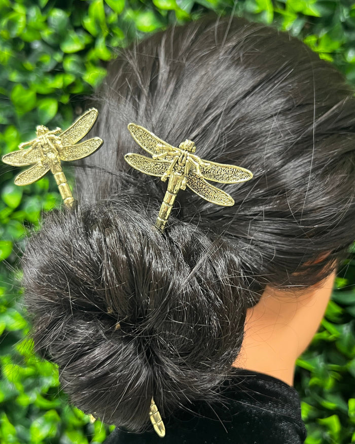 Gold Dragonfly Hair Sticks worn in a twisted bun hairstyle, model shown from an angled back view.