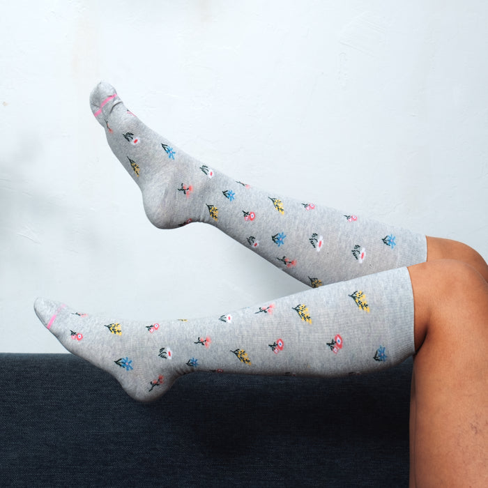 Knee-high compression socks with a gray background and colorful floral patterns.