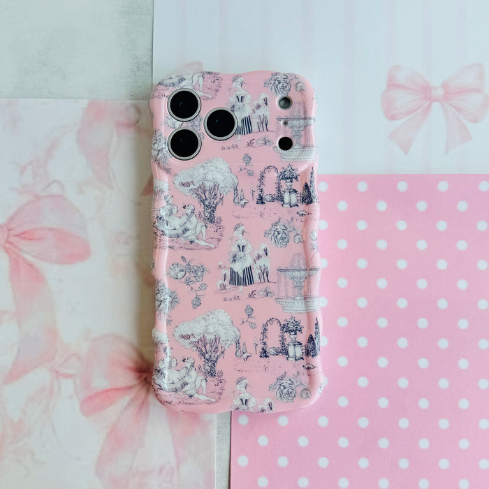 French Affair Wavy Luxe MagSafe iPhone case flat lay on pink polka dot and bow paper, showing the full toile de Jouy print.