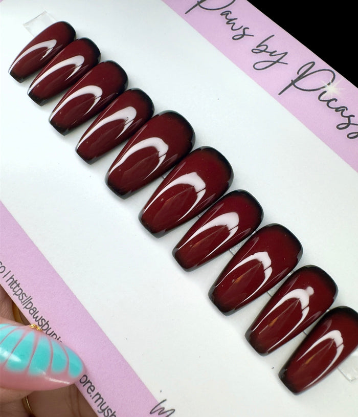 Set of brown nail extensions on a branded card.