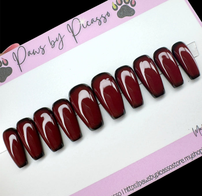 Set of maroon press-on nails on a 'Paws by Picasso' branded card.
