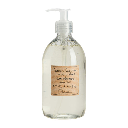 Clear glass bottle of liquid soap with a pump and wooden label on a white background