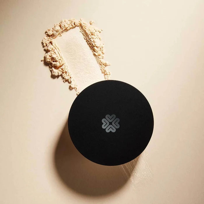 Swatch and pot of mineral shimmer powder on a light beige background.
