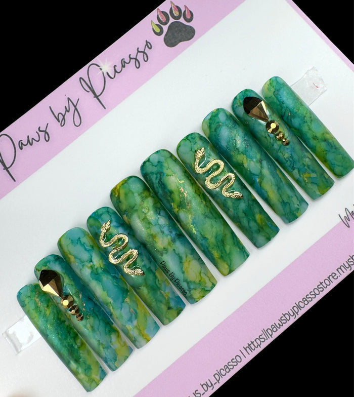 Set of green marbled dog nails with gold accents on a Paws by Picasso branded card.