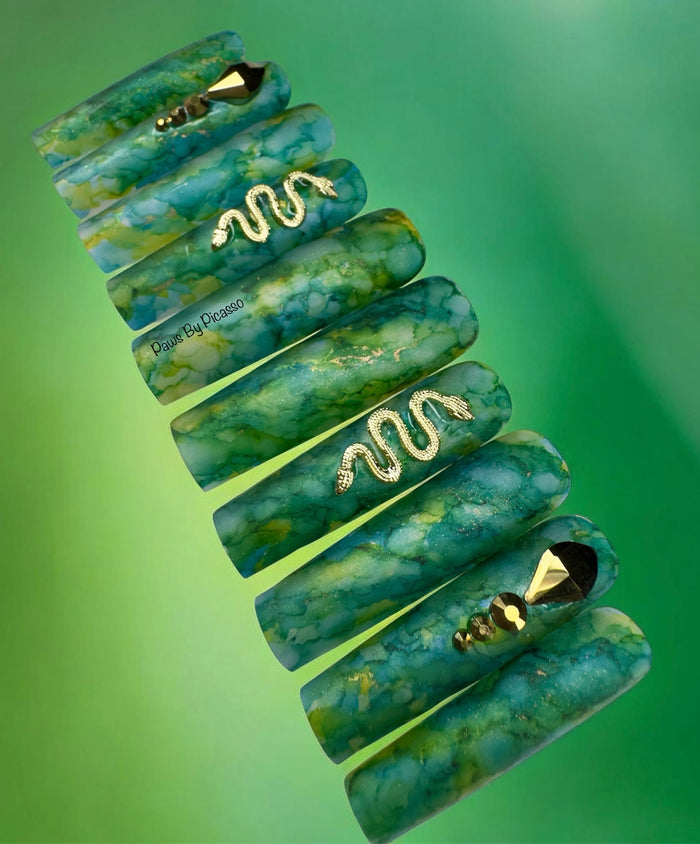 Set of green marbled hair clips with gold accents on a green background