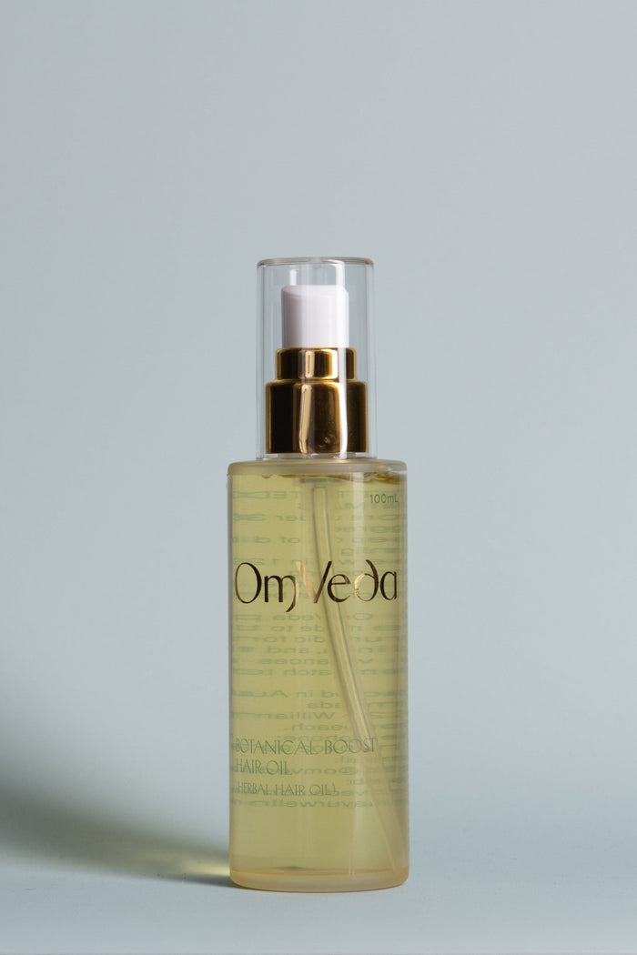 OmVeda Botanical Boost hair oil bottle with gold pump, clear yellow oil