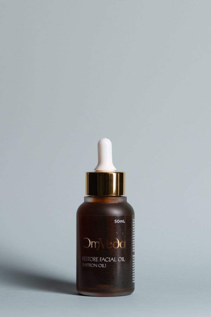 Facial oil bottle with white dropper and gold cap, dark amber glass; 50ml