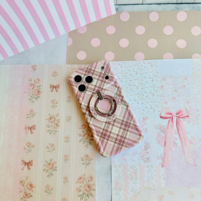 Pink Cashmere Plaid Wavy Luxe iPhone case with the matching MagSafe grip ring attached, styled on pink stripe and polka dot paper with a ribbon bow.