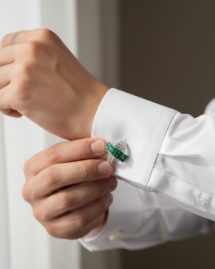 Silver cufflinks with green crystal wave design worn on a white shirt cuff
