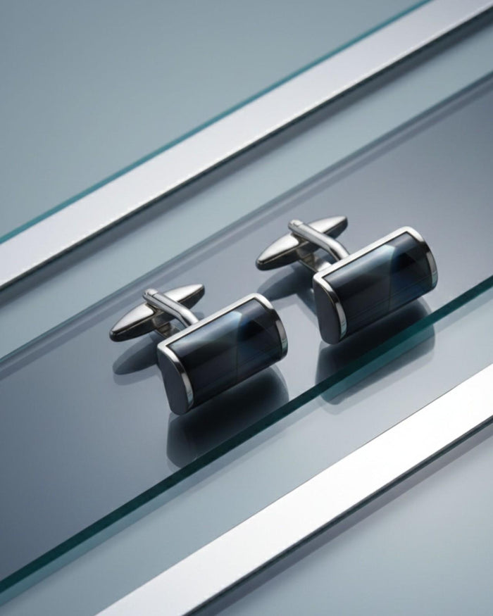 Pair of cylindrical silver-tone cufflinks with dark glossy resin barrels