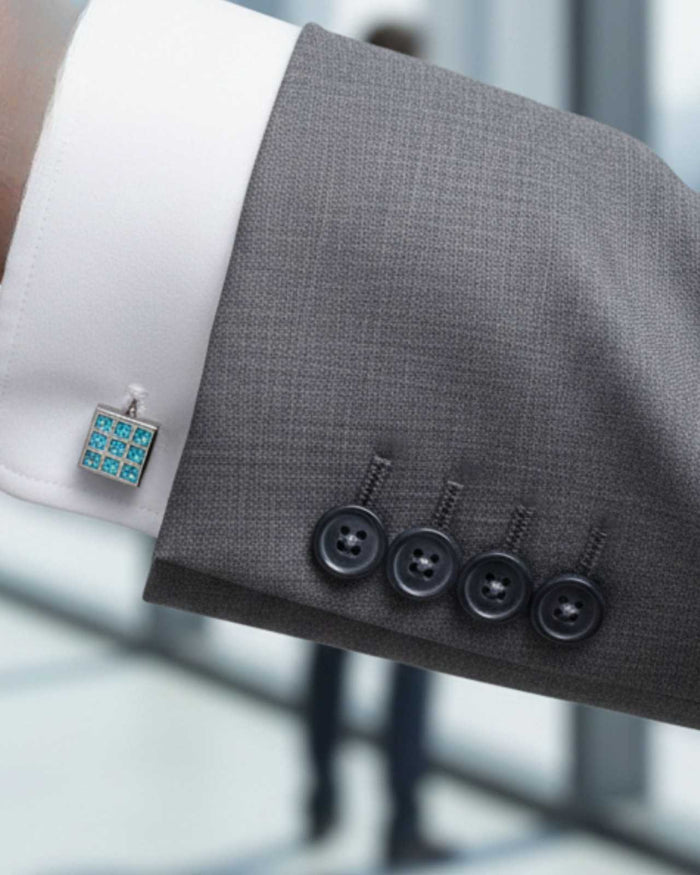 Rectangular aqua crystal cufflinks on gray suit cuff