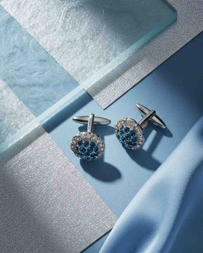 Round silver cufflinks with blue crystal cluster and pave crystal details, close-up