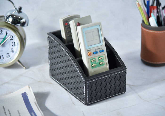 Woven remote holder in dark fabric with 3 compartments holding remotes