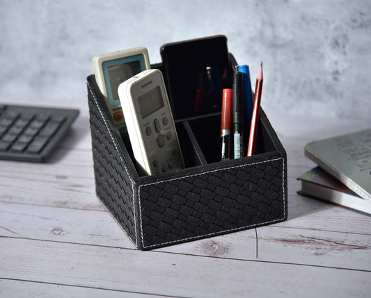 Black woven remote holder with three compartments, open top with remotes and pens