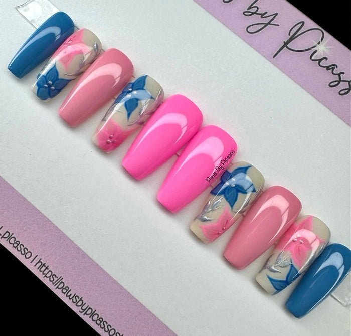 Set of pink and blue nails with floral design on a white background