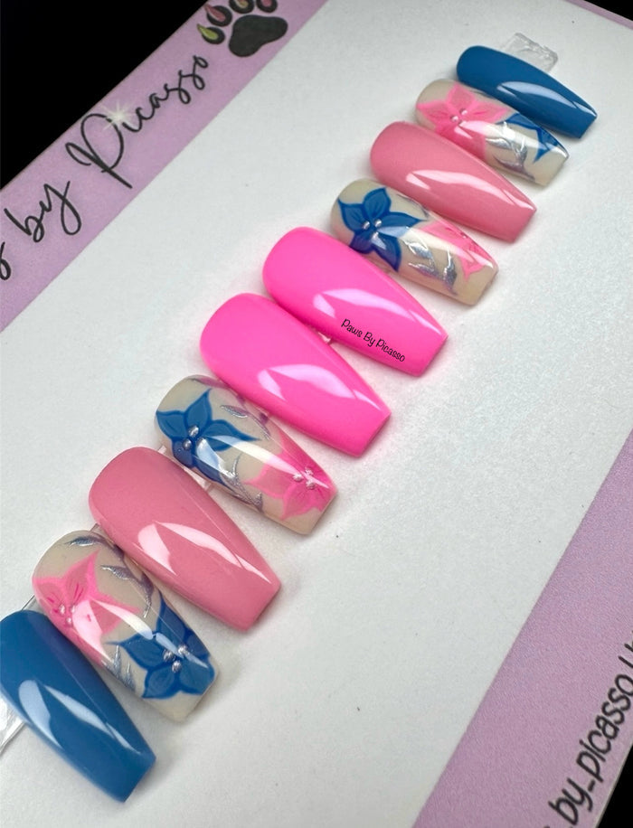 Set of pink, blue, and white nails with floral designs on a white background.