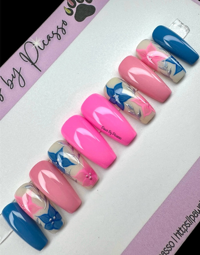 Set of pink and blue false nails with floral design on a branded card.