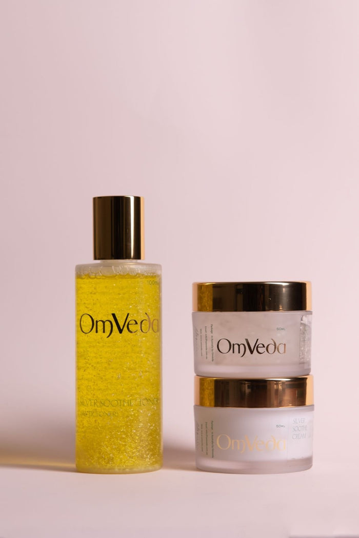 Skincare set: OmVeda yellow bottle and silver-lidded cream jar