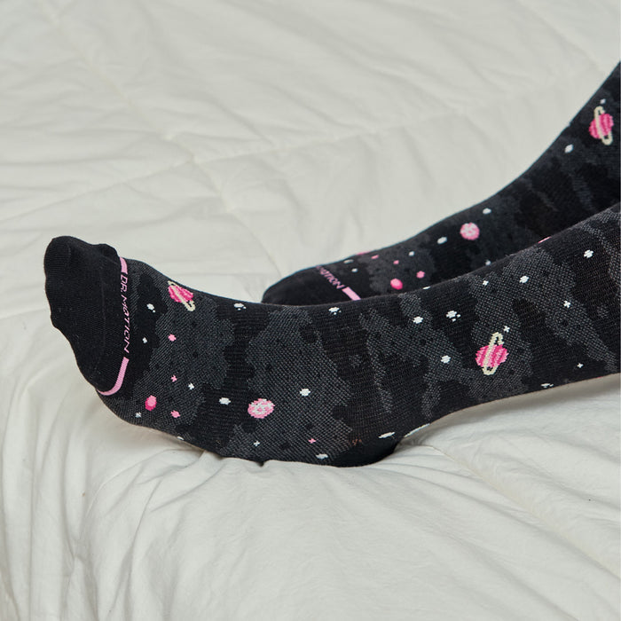 Knee-high black compression socks with a galaxy print featuring planets and stars.
