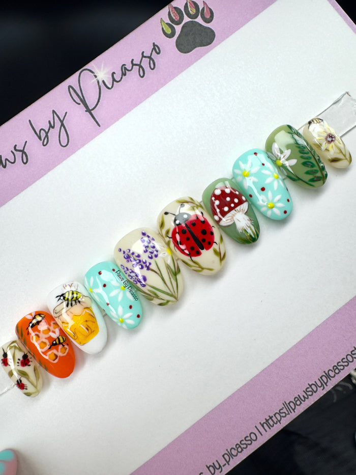 Decorative nail art on a white card with 'Paws by Picasso' branding.