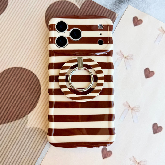 Sweet Espresso Stripes MagSafe grip ring attached to the matching Sweet Espresso Stripes iPhone case, styled flat on brown heart and bow paper.