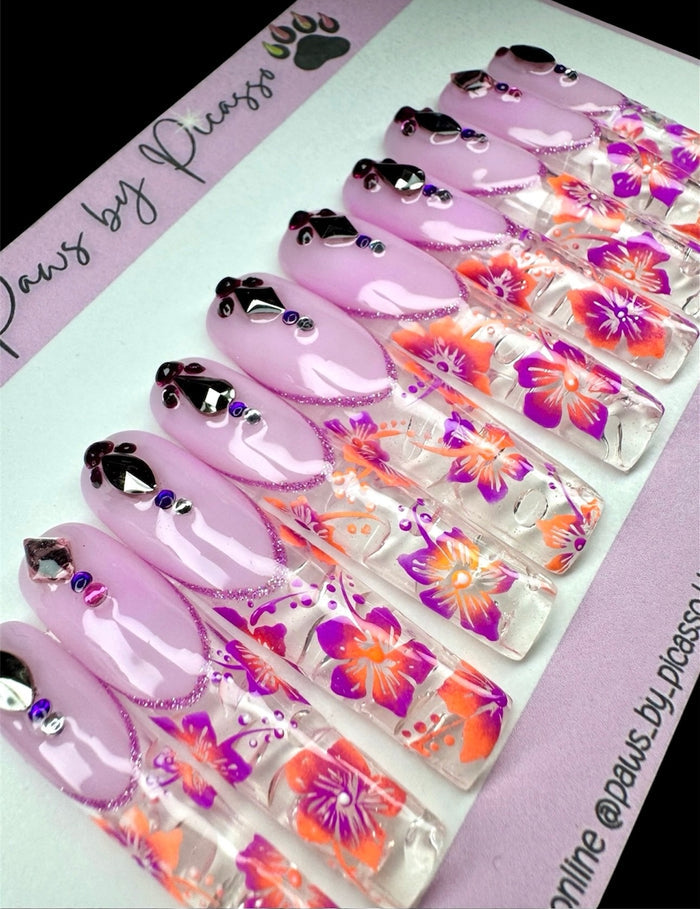 Set of purple nail art designs with floral patterns on a branded card.
